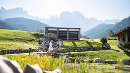 Naturbadeteich mit Blick auf den Rosengarten und Spa Hotel Gästen im 5 Sterne Luxushotel Cyprianerhof