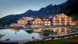 Abend Panorama mit beleuchtetem 5 Sterne Hotel Cyprianerhof in Tiers, Südtirol vor Naturbadeteich